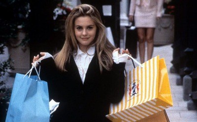 Alicia Silverstone hair flipped holding shopping bags in a scene from 'Clueless'.