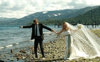 Newlyweds Alicia and Chris doing a walking through stones next to the lake after the ceremony ended.